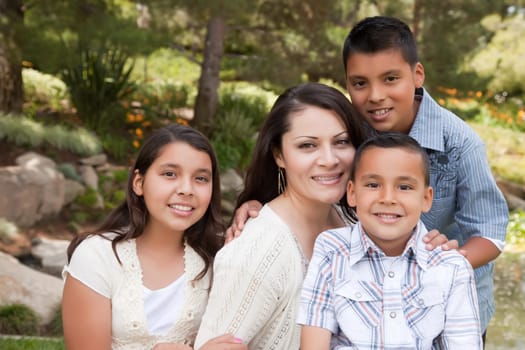 Happy Hispanic Mother and Children in the Park.