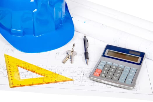 Construction plans with hard hat and drawing tools. Shallow depth of field