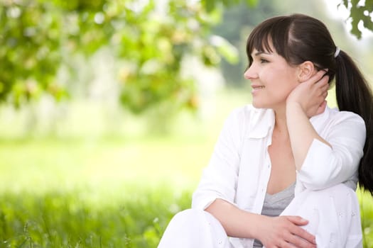 attractive brunette woman relaxing on grass