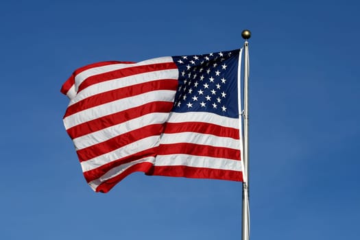 American flag waving against blue sky