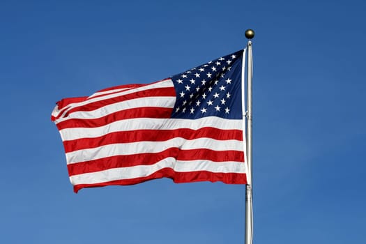 American flag waving against blue sky