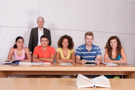 Group of happy students studying with lecturer