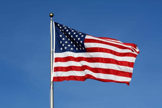 American flag waving against blue sky