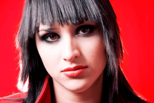 Portrait of fashion model wearing red coat over red background