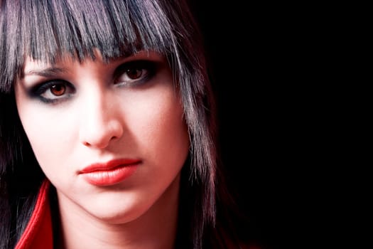 Closeup portrait of fashion model wearing red coat over dark background