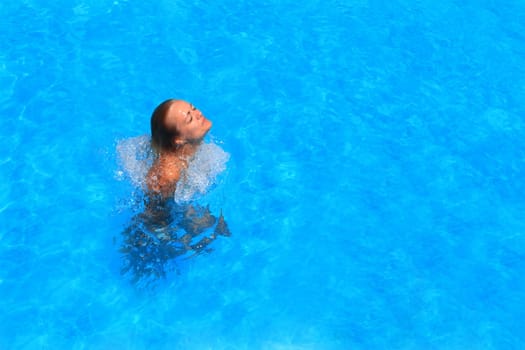 Pretty blonde woman enjoying a swimming pool in Greece