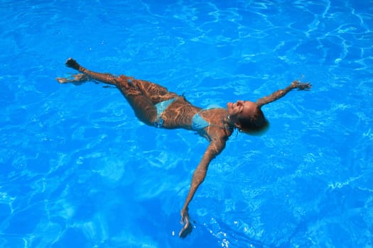 Pretty woman enjoying a swimming pool in Greece