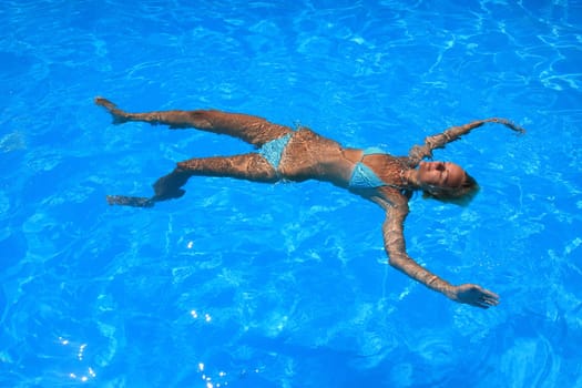 Pretty woman enjoying a swimming pool in Greece