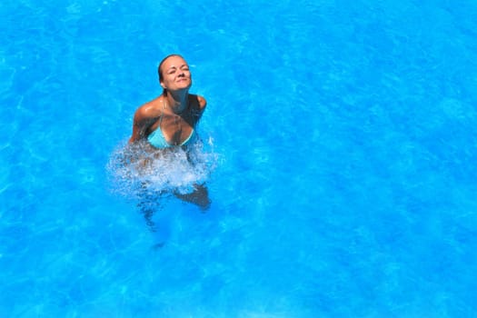Pretty blonde woman enjoying a swimming pool in Greece
