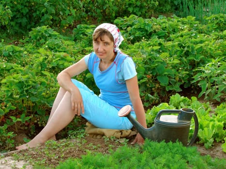woman resting near vegetable beds