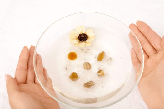 Female hands hold a cup with the salt cosmetic solution, isolated