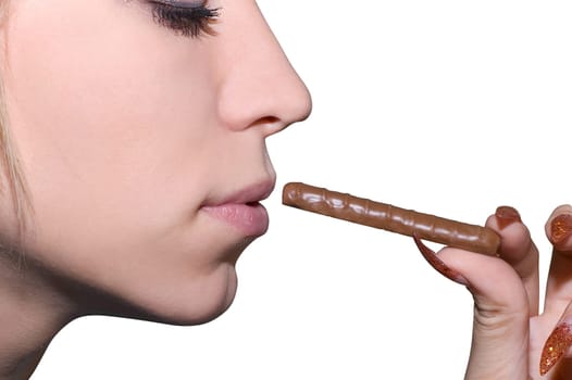 Female hand hold chocolate at lips on white background