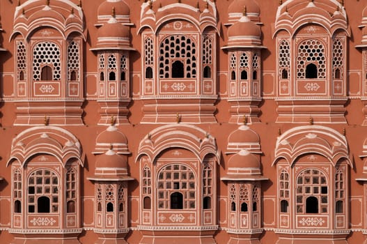 The Hawa Mahal or Palace of the Winds. Ornate pink and gold facade built to allow the ladies of the harem to view the streets below without being seen. Jaipur, Rajasthan, India