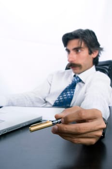 Businessman at his desk, concentrating on his job and playing with his pen