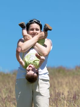 a mummy is playing with his son outdoors