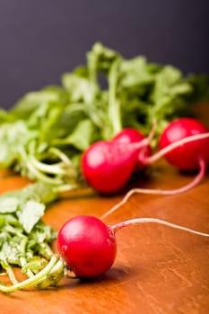 radish on a wood cutting board leaves and roots