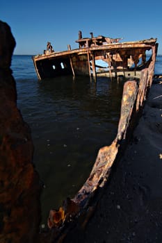 A sunken shipwreck rusting into the ocean