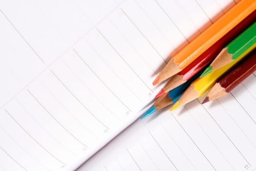 Close-up of color pencils and agenda