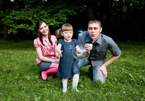 Soap Bubbles. Family Playing In The Park.