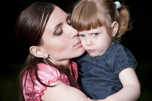 Mother Kissing Daughter Cheek. Close-Up Portrait
