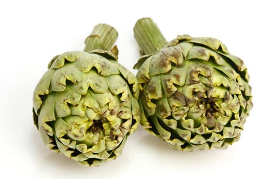 Two fresh artichokes over white background
