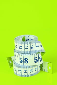 A measuring tape isolated agaist a lime green background