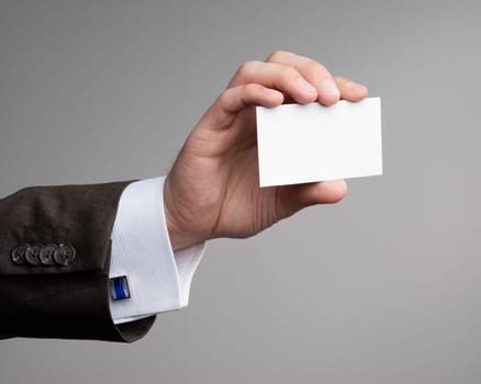 White visit card in hand isolated in studio