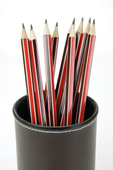 Lead pencils in a cup holder isolated against a white background