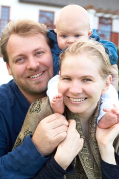 Beautiful happy family of three laughing. Focus is on the mother