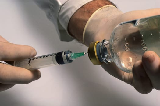 man with syringe and with a bottle