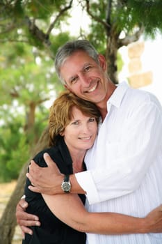 beautiful mature couple holding each other and looking at the camera