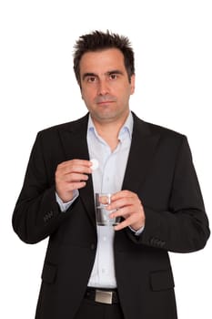 Young businessman keeps in his hands one bubble pill and a glass of water