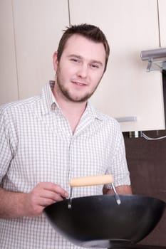 happy casual man cooking dinner in kitchen