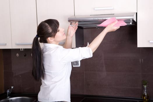 young brunette woman cleaning kitchen