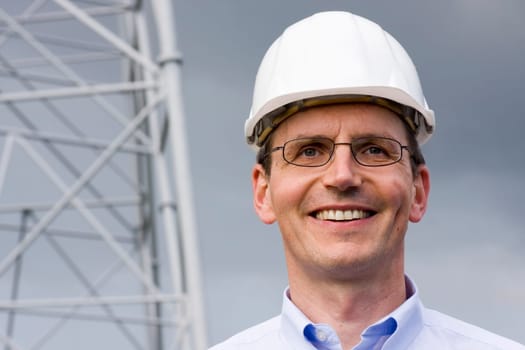 Smiling engineer with hardhat on construction site