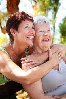 beautiful senior mother and daughter hugging and looking up