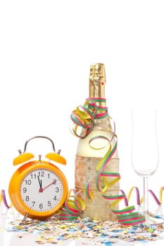 Champagne glass ready to bring in the New Year, with clock, ribbons and confetti