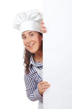 Smiling curious cook woman behind the white card isolated on white background