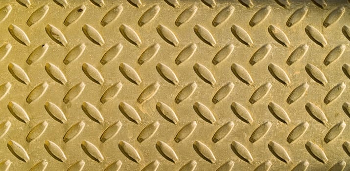 Diamond gold toned metal background texture illuminated by sunlight