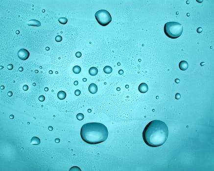 Water droplets on transparent blue surface
