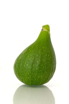 Immature fig before white background.
