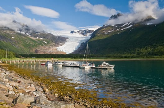 Boats on fjord by glacier in Norway