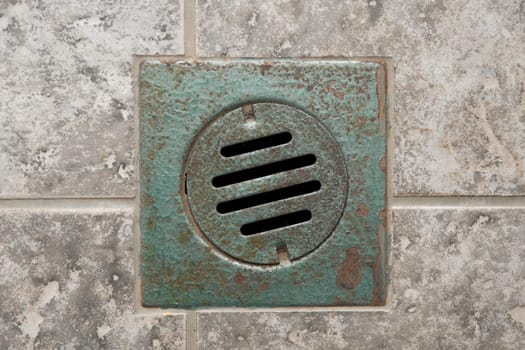 Rusty drain hole in a bathroom