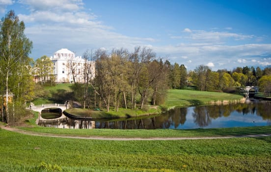 View of classical palace and bridge in picturesque park