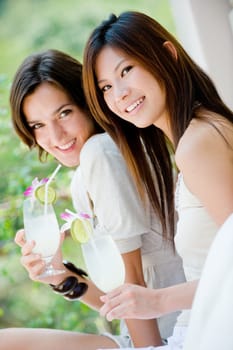 Two young women with lime drinks on vacation