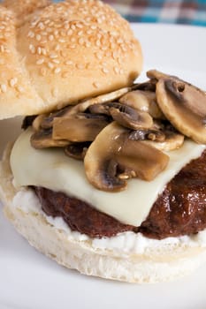A delicious burger topped with swiss cheese and sauteed mushrooms.