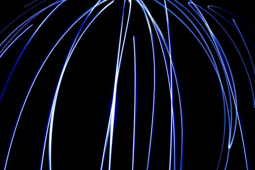 An abstract light background showing motion blurred light on a dark background.