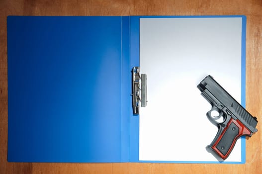 Concept with pistol and blank paper