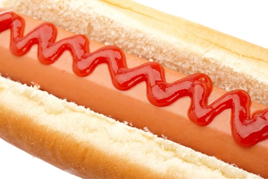 A hot dog with ketchup isolated on white background. Shallow depth of field