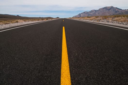 clean straight road through desert vanishing into distance